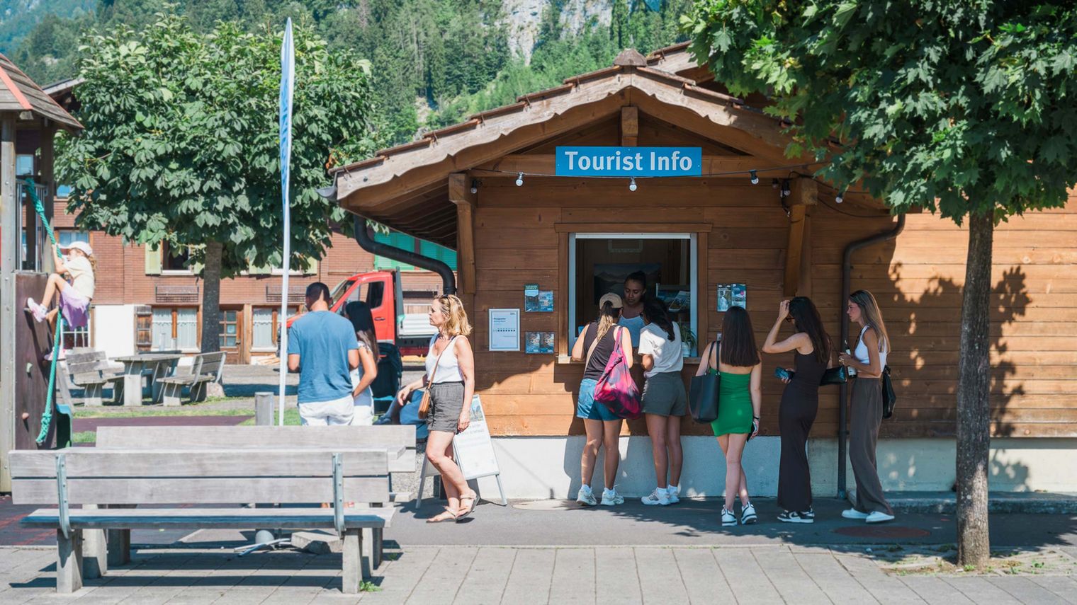 Besuchende in Isteltwald vor der Tourist Info am Schalter